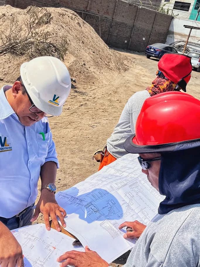 Equipo de VL Arquitectos en reunión técnica revisando planos sobre la mesa de trabajo